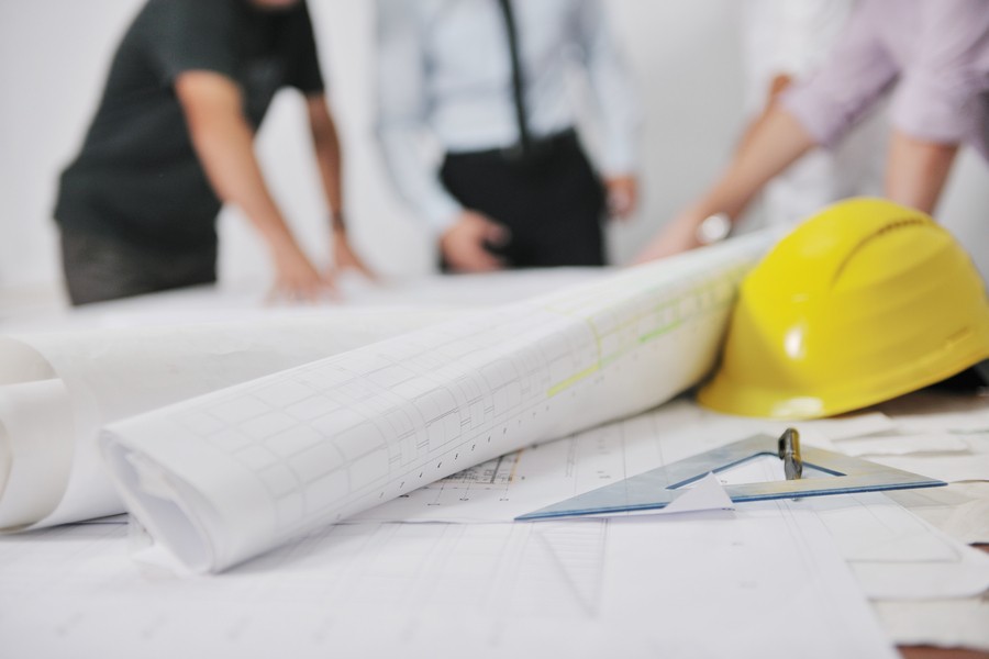 Blueprints, a yellow hard hat, and construction planning tools on a table, symbolizing Control4 installation planning in Bountiful, UT.